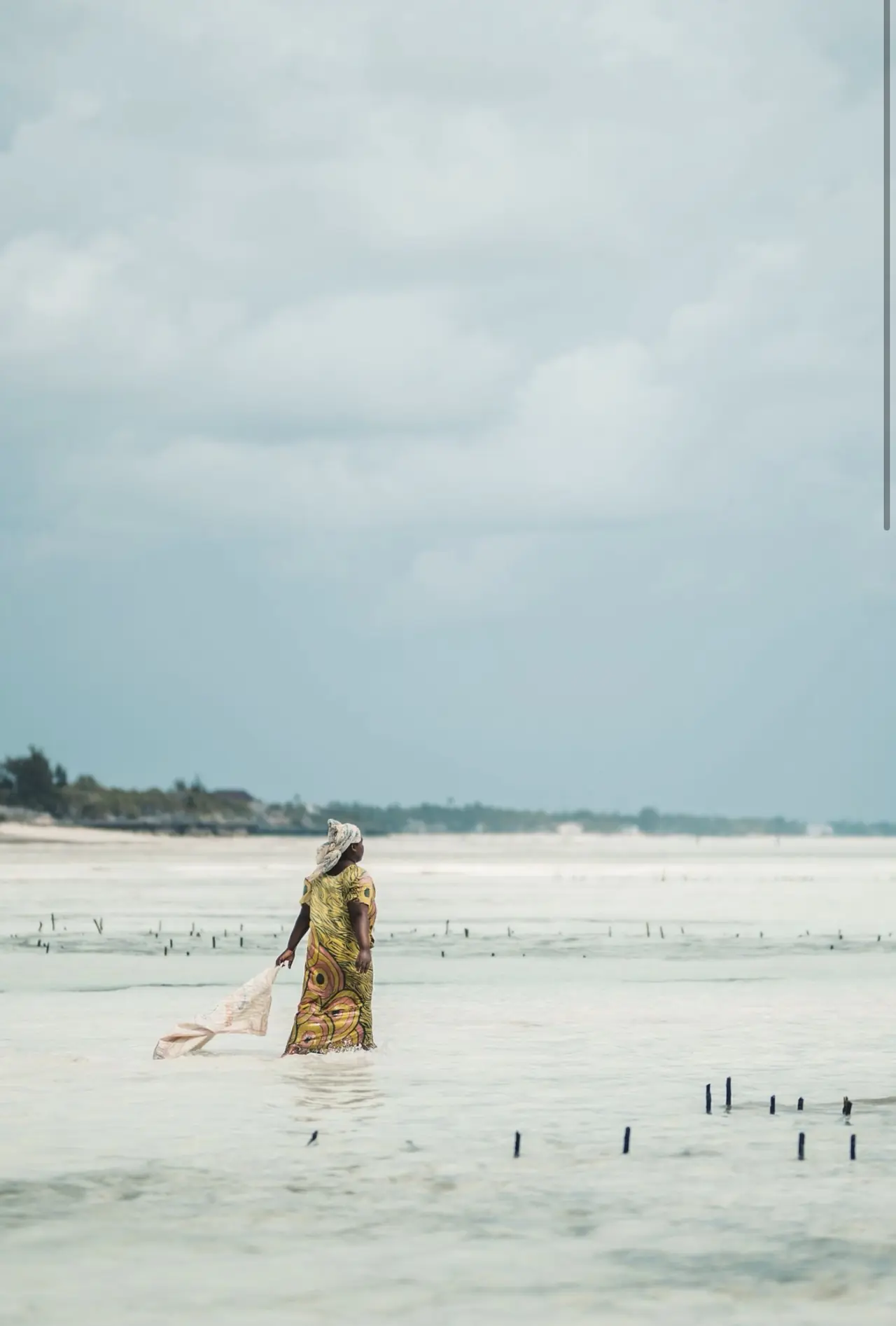 Mujer caminando por la marea baja en Zanzíbar